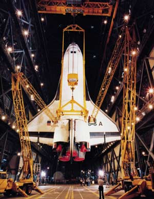 Space Shuttle being hoisted into the air by cranes